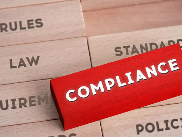 Red wooden tile labeled COMPLIANCE, on many wooden tiles labeled RULES, LAW, STANDARDS, etc